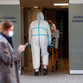 Un sanitario traslada a un enfermo en el Hospital Clínico de València.