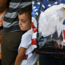 Un niño migrante de Guatemala de cinco años y su familia esperan con otros solicitantes de asilo, liberados tras ser detenidos en la frontera de EEUU con México.- REUTERS