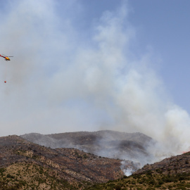 19/06/2022 - Un helicòpter dels Bombers es dirigeix a una columna de fum a la serra de Sant Mamet, a Artesa de Segre.