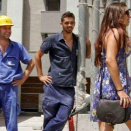 Dos obreros miran descaradamente a una joven en la calle. | EFE