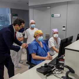 El presidente de la Junta, Juanma Moreno, junto al personal sanitario del nuevo Hospital de Emergencia Covid-19, construido en el antiguo Hospital Militar Vigil de Quiñones en Sevilla, que ha entrado hoy en funcionamiento.