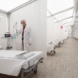 Un sanitario enciende un respirador del hospital de campaña de La Fe de València que ya se encuentra preparado por si tuvieran que derivarse a ellos pacientes con covid.