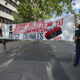 28/06/2022. Dos hombres sujetan una pancarta durante una concentración por los trabajadores fallecidos por el amianto frente a los Juzgados de Plaza de Castilla, a 14 de junio de 2021, en Madrid.