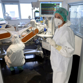 Personal sanitario del Hospital Universitario Marqués de Valdecilla de Santander atiende, este jueves, a enfermos con coronavirus en una de las UCI-Covid del hospital cántabro.