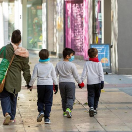 Fotografía de archivo de una madre y sus hijos tras hacer la compra en Zaragoza. EFE/ Javier Belver