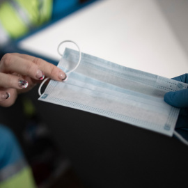 Dos trabajadores de una UVI móvil del SUMMA 112 se dan una mascarilla en la visita a un domicilio durante una jornada de trabajo