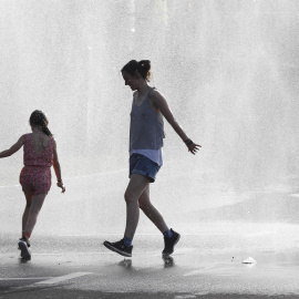 Dos personas se refrescan durante la ola de calor en Vitoria.