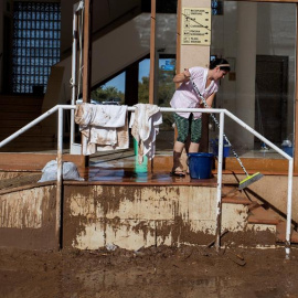 11/10/2018.- Una mujer en las tareas de limpieza en la desembocadura del torrente desbordado en S'Illot, Manacor, tras el temporal. EFE /LLITERES