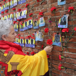 14/07/2022. Una mujer coloca una rosa en una pared durante una ofrenda floral y encuentro abierto entre familiares de las víctimas y estudiantes daneses del franquismo, en el cementerio de La Almudena, a 12 de abril de 2022, en Madrid