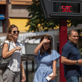 Varias personas pasan ante un termómetro al sol que marca 50 grados, hoy martes en Ourense, que supera las previsiones y llega a los 43,5 grados
