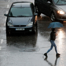 Una persona se protege de la lluvia con un paraguas durante la mañana de este viernes en la que el cielo de la Comunidad Valenciana permanece cubierto con precipitaciones fuertes o muy fuertes, sobre todo en Castellón y Valencia - EFE/Kai Försterling
