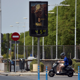 18/07/2022 - Una persona pasa en bicicleta por delante de un termómetro que marca 45º durante la ola de calor en Sevilla, el 10 de julio de 2021.