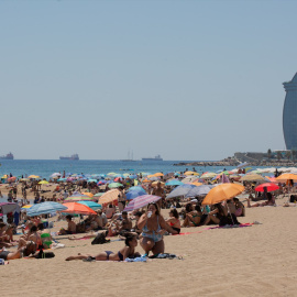La gente se refugia del calor en la playa de La Barceloneta en Catalunya. Imagen de Archivo.