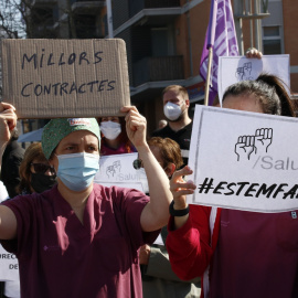 Dues treballadores de l'Hospital Joan XXIII, protestant durant la vaga, amb cartells on s'hi llegeix "Millors contractes" i "Estem fartes". 10 de març del 2021.