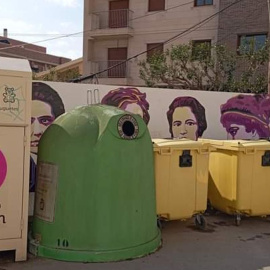 Imagen del muro feminista en Archena (Murcia) oculto tras los contenedores.