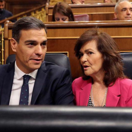 El presidente del gobierno Pedro Sánchez, conversa con la vicepresidenta del gobierno Carmen Calvo en el Congreso de los Diputados. (BALLESTEROS | EFE)
