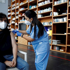 Una profesional sanitaria administra la vacuna contra la covid-19 a un ciudadano en los pasillos del Hotel SB Plaza Europa, ubicado cerca del recinto de Fira de Barcelona de L'Hospitalet de Llobregat.