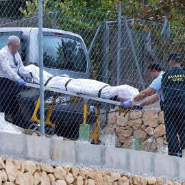 Miembros de los servicios funerarios trasladan el cuerpo de una de las víctimas de Finestrat.   EFE