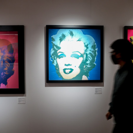 Un visitante pasa junta a varios retratos de Marilyn Monroe del artista estadounidense Andy Warhol en una exposición en febrero de 2022 en Madrid. E.P./ Ricardo Rubio