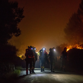 Varios bomberos forestales trabajan en la extinción del incendio de Cures, en Boiro, A Coruña, en la madrugada de este sábado.