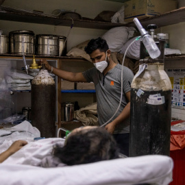 1/05/2021. Una mujer contagiada de covid-19 es tratada por el personal médico en una sala de urgencias abarrotada, en un hospital de Nueva Delhi. - Reuters