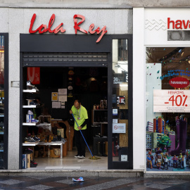 Un trabajador limpia la entrada de una tienda de zapatillas en Madrid. REUTERS/Susana Vera