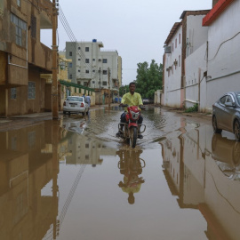 Un hombre tratar de pasar por una calle inundada en Jartum, a 13 de agosto de 2022.