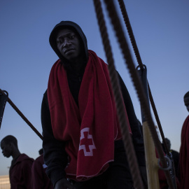 Un joven migrante sube a borde de un barco de Sasemar junto a otros 200 personas para pasar la noche tras ser rescatado de una patera durante el fin de semana. JAIRO VARGAS