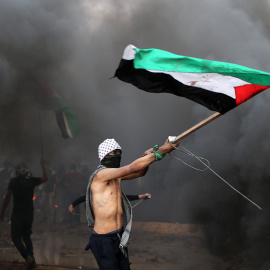 Un manifestante ondea una bandera de Palestina durante las protestas en la frontera con Israel en Gaza del viernes 26 de octubre. Mohammed Salem/REUTERS