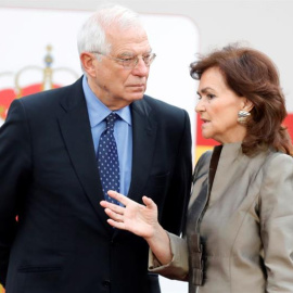 La vicepresidenta del Gobierno, Carmen Calvo y el ministro de Exteriores, Josep Borrell, conversan antes del inicio del desfile militar, uno de los actos conmemorativos del Día de la Fiesta Nacional, que presiden los Reyes junto a sus hijas, la princesa