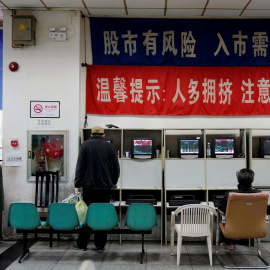 Los inversores miran los monitores que muestran información sobre acciones en una firma de brokers en Shanghai (China). REUTERS / Aly Song