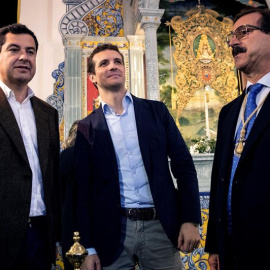 El presidente del PP, Pablo Casado (c), acompañado del presidente del PP-A, Juanma Moreno (i), y del presidente de la Hermandad del Rocío de Huelva, Antonio Sánchez de Piña. /EFE