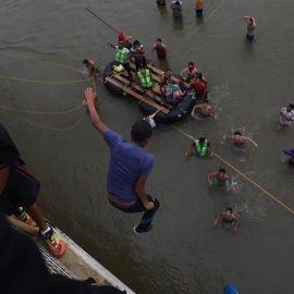 Migrantes hondureños que se encuentran en la frontera de México y Guatemala, se lanzan del puente hacia el río Suchiate para cruzar hacia México. EFE/EDWIN BERCÍAN