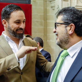 El líder nacional de Vox, Santiago Abascal, y el diputado de esa formación, el juez Francisco Serrano, conversando al inicio de la segunda jornada del debate de investidura del presidente del PP andaluz, Juanma Moreno, en el Parlamento andaluz en Sevill