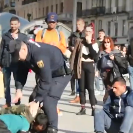 Un agente antidisturbios golpea a uno de los implicados en una pelea en la Puerta del Sol (Madrid). / TWITTER