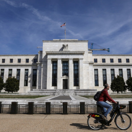 Un hombre en bicicleta pasa delante del edificio de la Reserva Federal, en la Avenida Constitución de Washington. REUTERS/Brendan McDermid