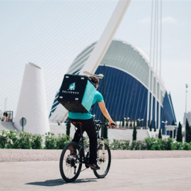 Un repartidor de Deliveroo, junto a la Ciudad de las Artes y las Ciencias de Valencia. E.P.