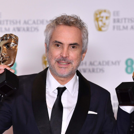 El director mexicano Alfonso Cuarón posa con los premios a mejor director y a la mejor película por "Roma" en los Premios BAFTA el 10 de febrero de 2019 | AFP