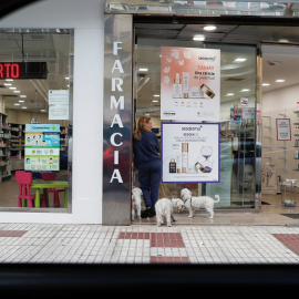 Una mujer espera con sus perros en el exterior de una farmacia en Benidorm. REUTERS/Jon Nazca