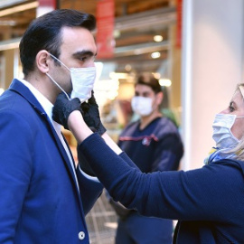 Mujer poniendo ayudando a poner una mascarilla en Austria a principios de la pandemia-01/04/2020