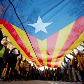 Manifestantes portan una gran estelada durante la movilización. EFE/Enric Fontcuberta