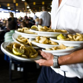 Un camarero con platos de calamares, en una imagen de archivo. / EFE