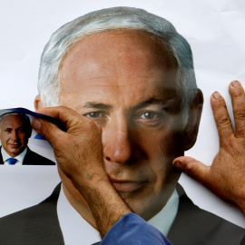 Un partidario del Partido Likud coloca un cartel que representa al líder del partido, Benjamin Netanyahu, en la aldea drusa de Yarka, Israel, el 8 de febrero de 2009. / REUTERS - AMMAR AWAD