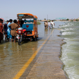 Las personas desplazadas en una carretera inundada, luego de las lluvias e inundaciones durante la temporada del monzón en Sehwan, Pakistán. -REUTERS
