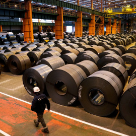 Un trabajador pasa junto a los rollos de acero de la planta de ArcelorMittal en Sestao. REUTERS