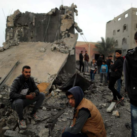 Un grupo de jóvenes palestinos observa los restos de un edificio destruido por la aviación de Israel. (SUHAIB SALEM)
