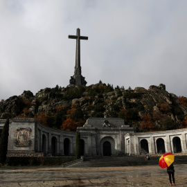 Un hombre con un paraguas con los colores de la bandera española en la explanada de la Basílica del Valle de los Caidos. REUTERS/Susana Vera