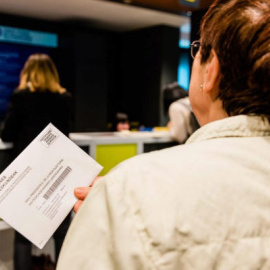 Una mujer hace cola en una oficina de correos para depositar su voto. | EFE