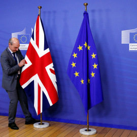 Un empleado de la Comisión Europea coloca la bandera británica.- REUTERS
