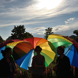 Personas sostienen paraguas arco iris para celebrar el Día Internacional contra la Homofobia frente al edificio del Parlamento rumano en Bucarest. DANIEL MIHAILESCU / AFP